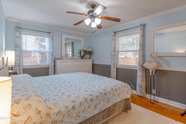 bedroom featuring multiple windows, ceiling fan, light hardwood / wood-style floors, and ornamental molding