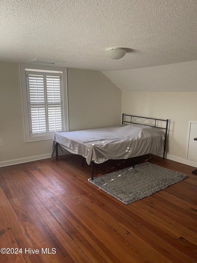 unfurnished bedroom featuring a textured ceiling, dark hardwood / wood-style flooring, vaulted ceiling, and pool table