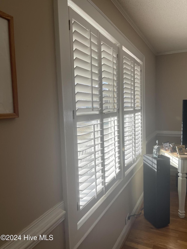 details featuring a textured ceiling, hardwood / wood-style flooring, and ornamental molding