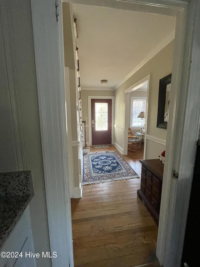 doorway to outside with wood-type flooring and ornamental molding