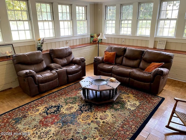 living room with wood walls and light parquet flooring