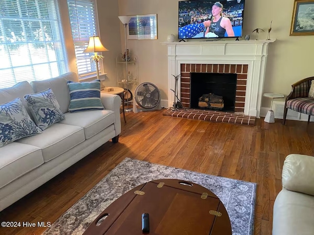 living room with hardwood / wood-style floors and a brick fireplace