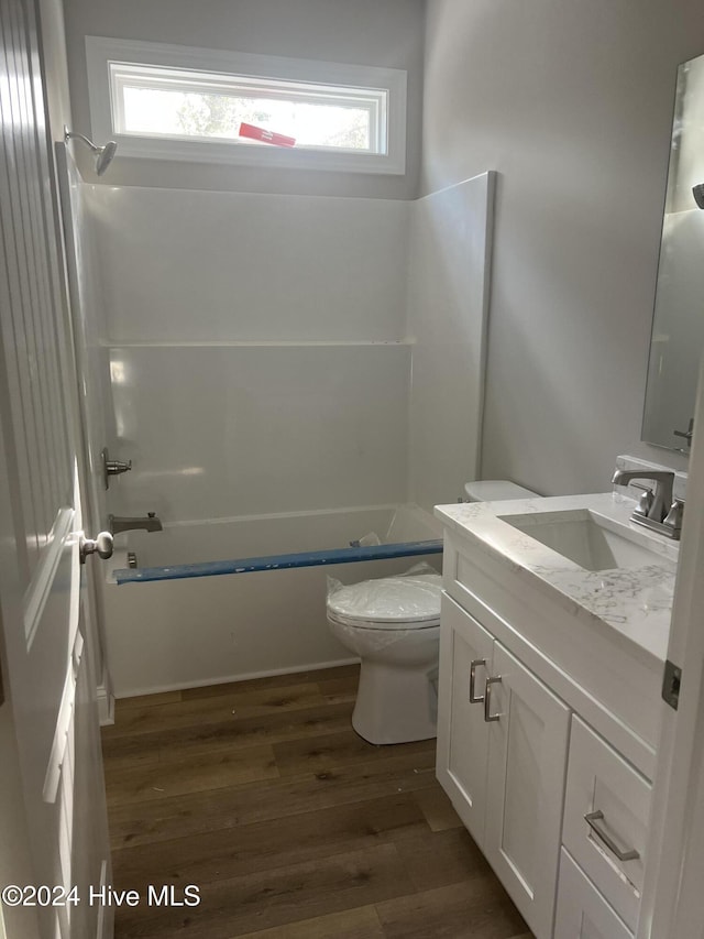 full bathroom with toilet, vanity, bathtub / shower combination, and hardwood / wood-style flooring