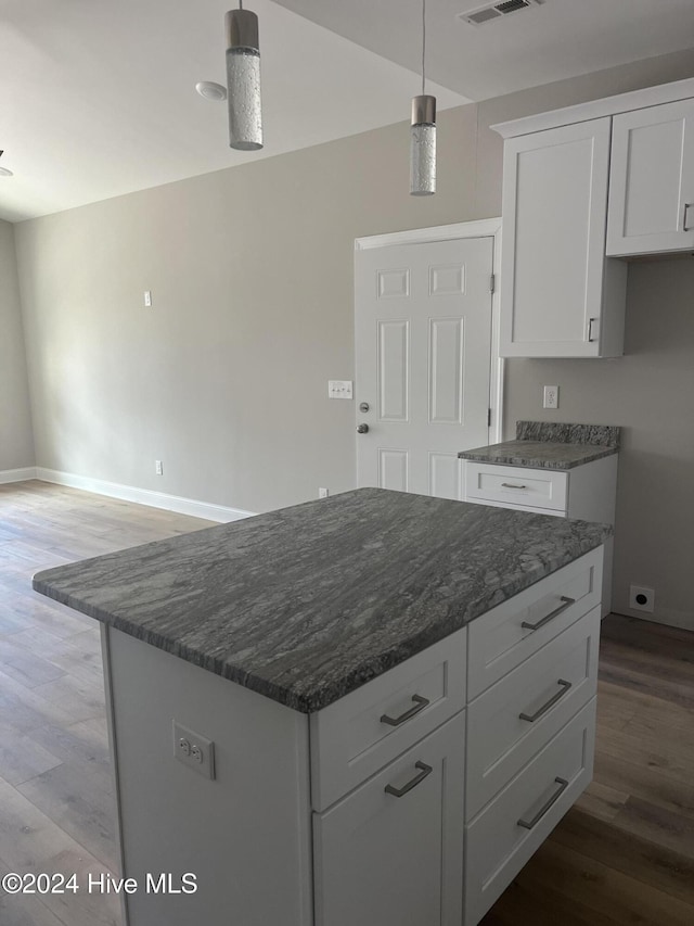 kitchen featuring white cabinets, a center island, light hardwood / wood-style floors, and hanging light fixtures