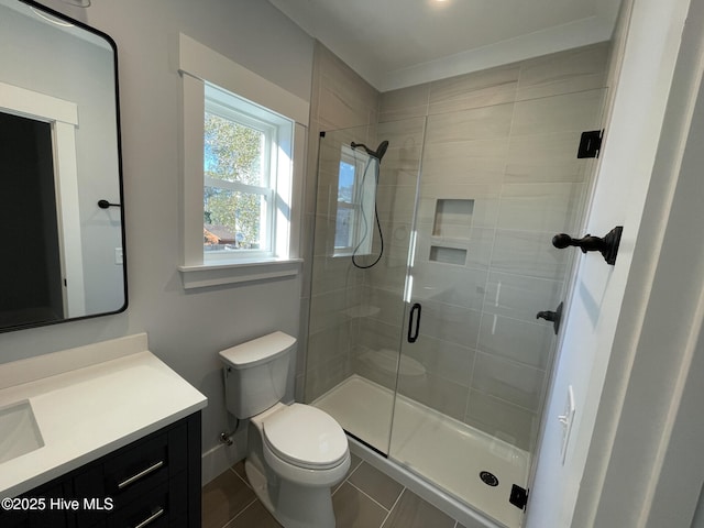 bathroom featuring vanity, tile patterned flooring, a shower with shower door, and toilet