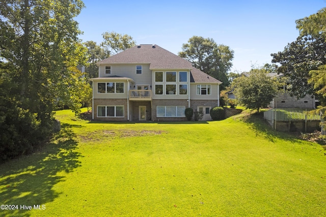 rear view of property featuring a lawn