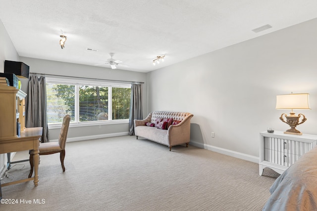 interior space featuring a textured ceiling, light colored carpet, and ceiling fan