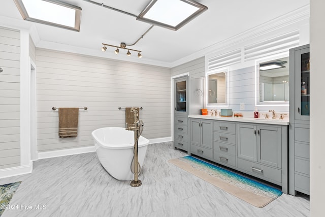 bathroom with vanity, crown molding, a bathing tub, and wood walls