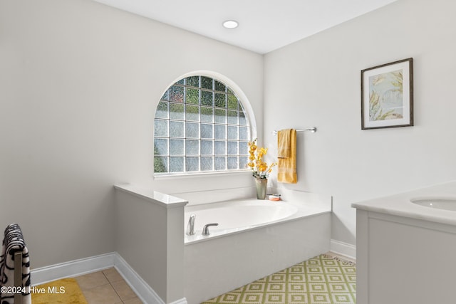 bathroom with tile patterned flooring, vanity, and a tub to relax in