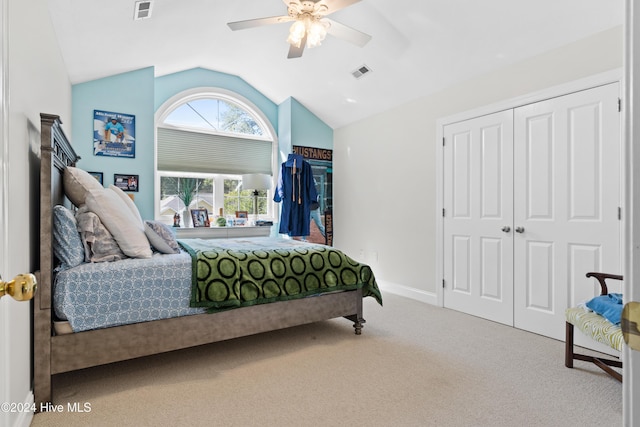 carpeted bedroom with ceiling fan, lofted ceiling, and a closet