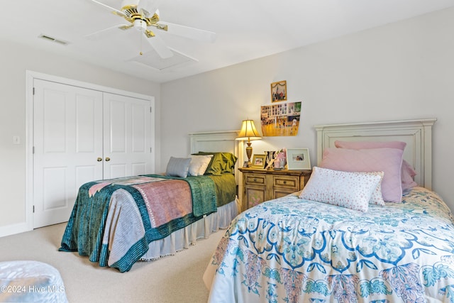 bedroom with ceiling fan, a closet, and light colored carpet