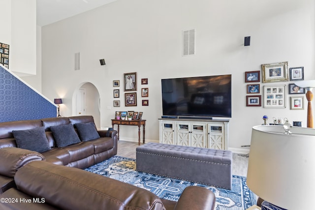 living room featuring high vaulted ceiling and wood-type flooring