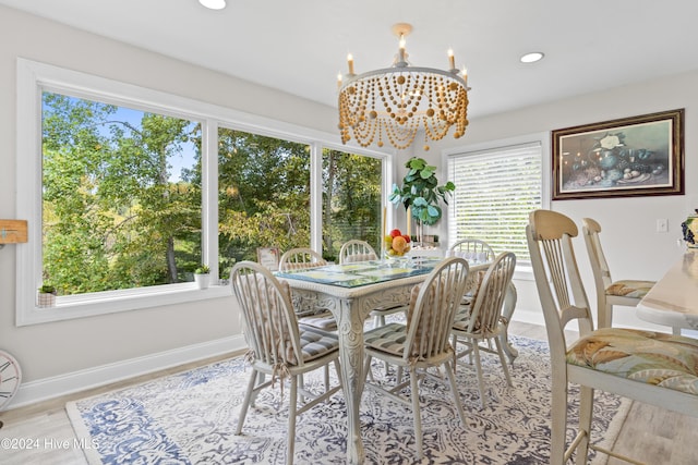 dining room with a chandelier, a healthy amount of sunlight, and light hardwood / wood-style flooring