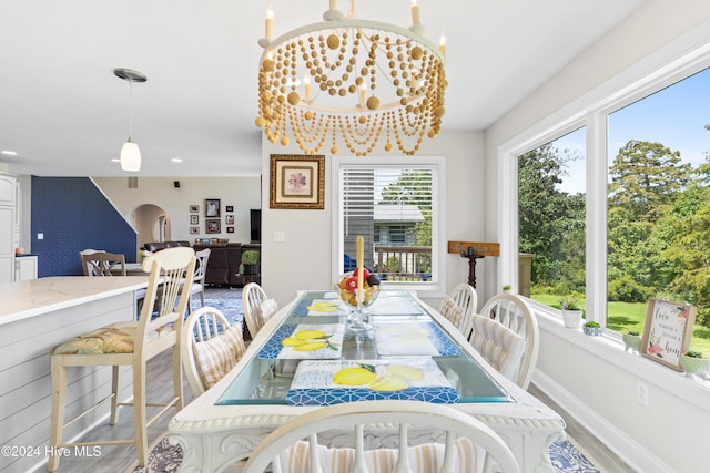 dining area with light hardwood / wood-style flooring and an inviting chandelier