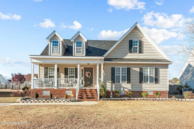 cape cod house with a front lawn and covered porch