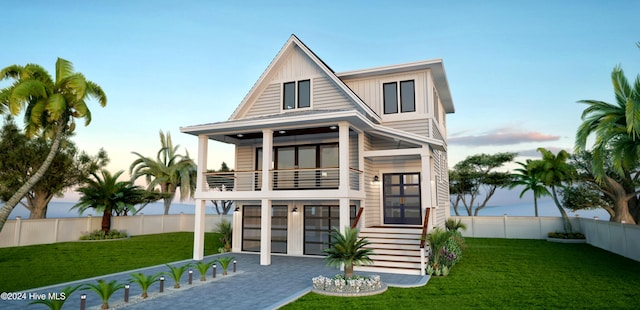 view of front of property featuring a balcony, a garage, and a front lawn