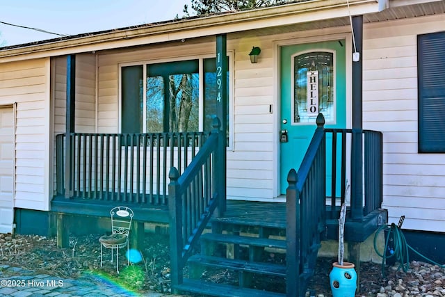 view of exterior entry featuring covered porch