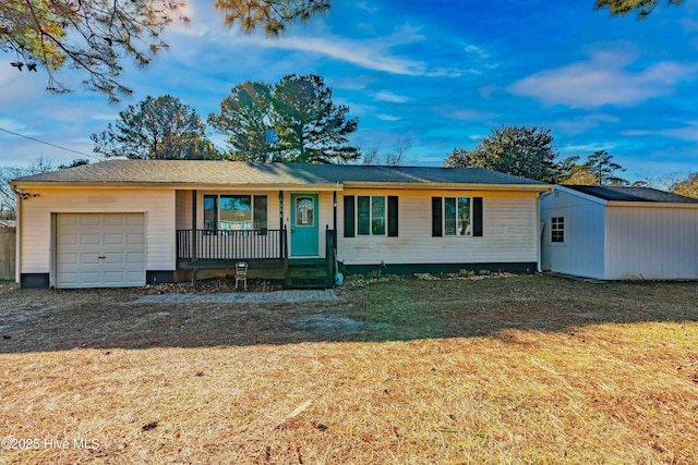 ranch-style house featuring covered porch, a garage, and a front lawn