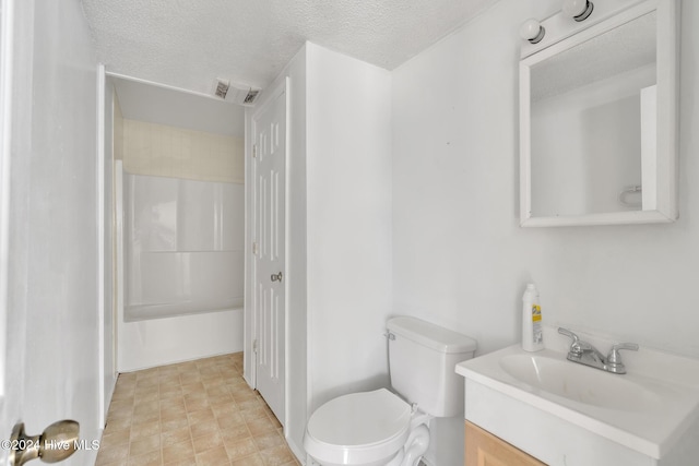 bathroom with a textured ceiling, vanity, and toilet