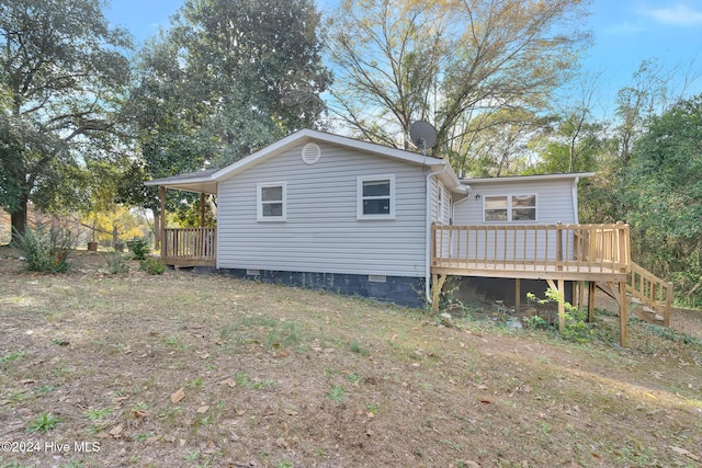 rear view of house featuring a wooden deck