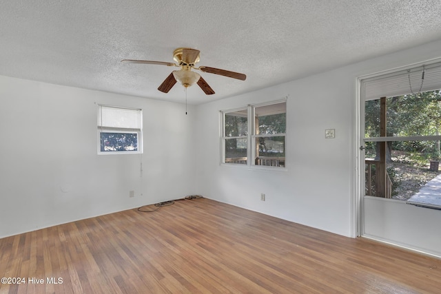 spare room with ceiling fan, a textured ceiling, and hardwood / wood-style flooring