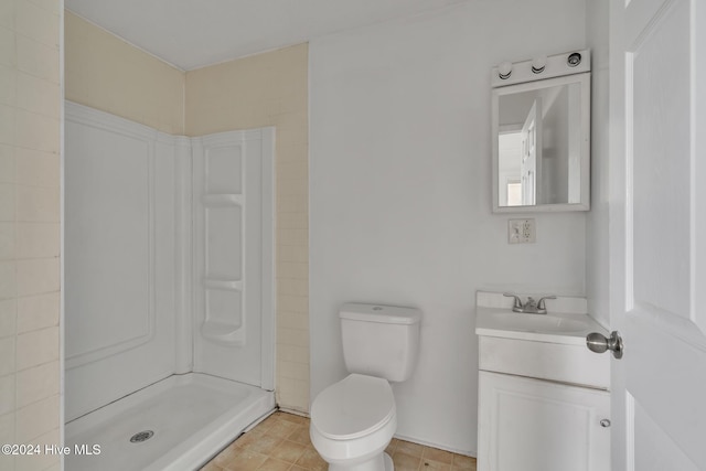 bathroom with a shower, vanity, and toilet