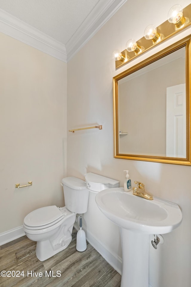 bathroom with wood-type flooring, a textured ceiling, toilet, and crown molding