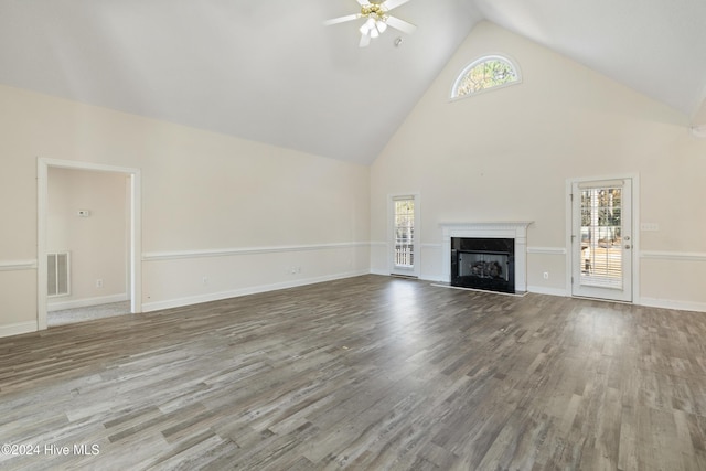 unfurnished living room with hardwood / wood-style flooring, ceiling fan, and high vaulted ceiling