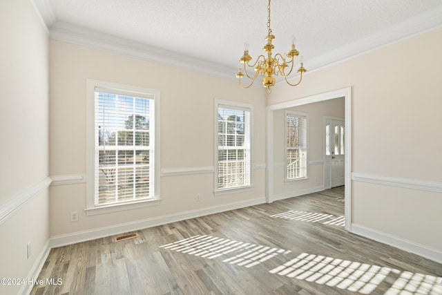 unfurnished room featuring hardwood / wood-style flooring, crown molding, a textured ceiling, and an inviting chandelier