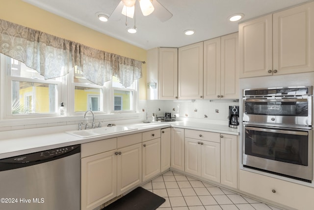 kitchen featuring ceiling fan, sink, stainless steel appliances, tasteful backsplash, and light tile patterned flooring