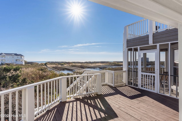 wooden deck featuring a sunroom and a water view