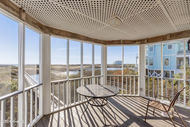 unfurnished sunroom featuring a water view