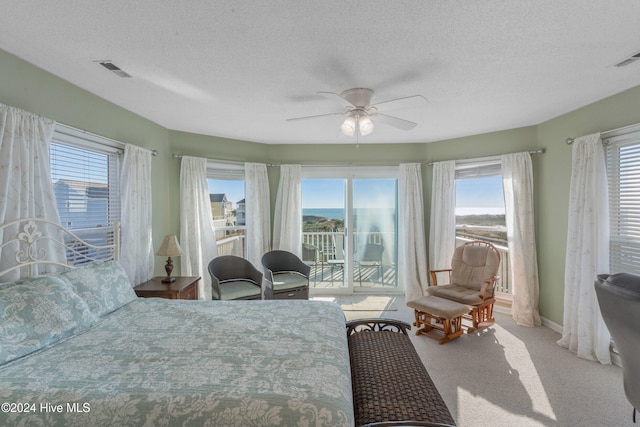 carpeted bedroom with multiple windows, a textured ceiling, and ceiling fan