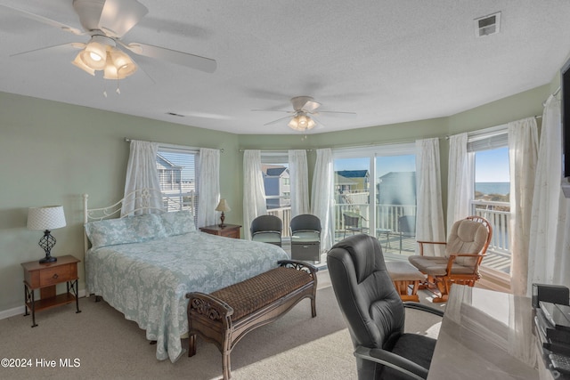 bedroom with a textured ceiling, ceiling fan, light carpet, and access to outside