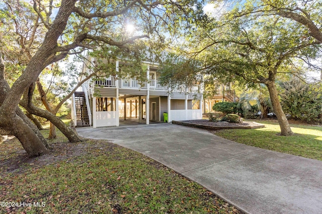 view of front of house with covered porch, a front lawn, and a carport