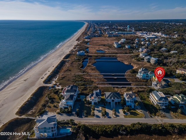 birds eye view of property with a water view and a view of the beach