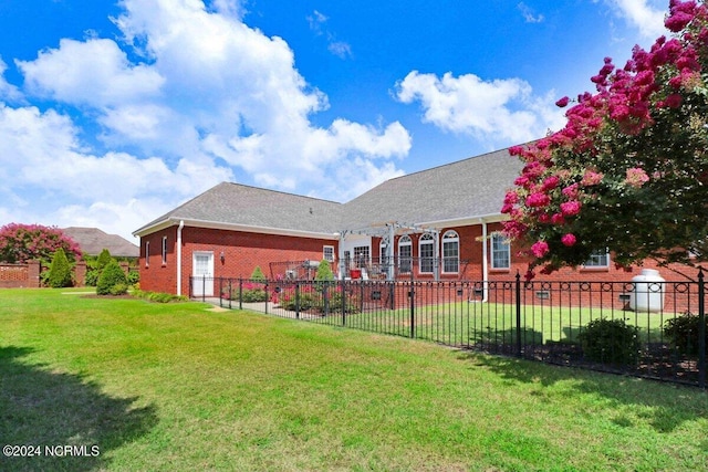 rear view of house featuring a yard