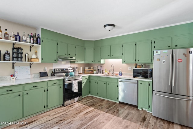 kitchen featuring appliances with stainless steel finishes, light hardwood / wood-style flooring, crown molding, and sink