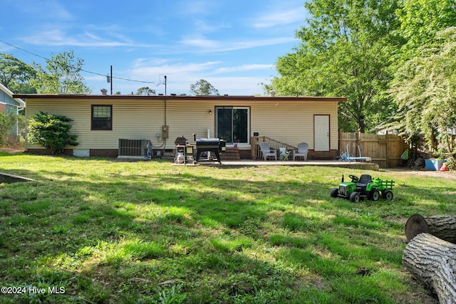 back of house with a lawn, central AC unit, and a patio area