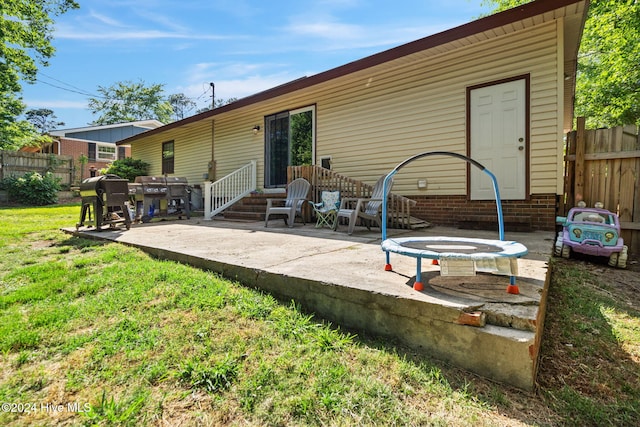 back of house with a lawn and a patio