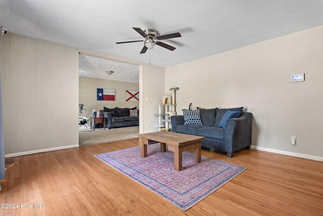 living room featuring hardwood / wood-style floors, ceiling fan, and a textured ceiling