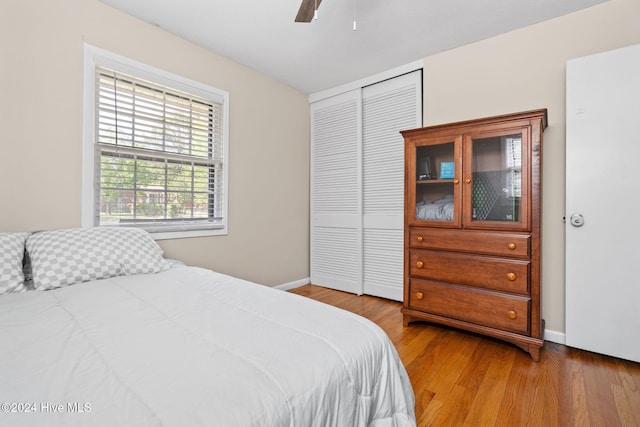 bedroom with hardwood / wood-style flooring, a closet, and ceiling fan