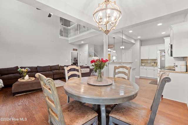 dining area featuring light hardwood / wood-style floors and an inviting chandelier