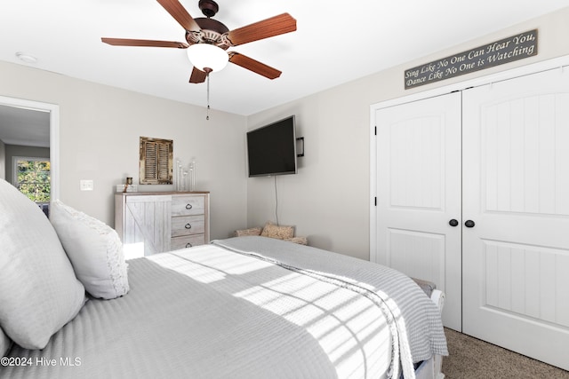 carpeted bedroom with ceiling fan and a closet