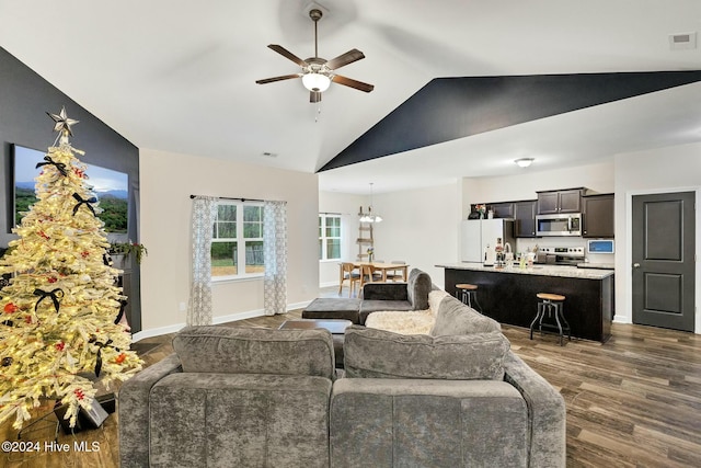 living room with dark hardwood / wood-style flooring, ceiling fan with notable chandelier, and vaulted ceiling