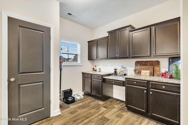 kitchen with dark brown cabinetry and hardwood / wood-style flooring