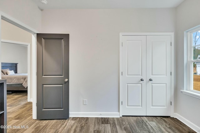 unfurnished bedroom featuring wood-type flooring and a closet