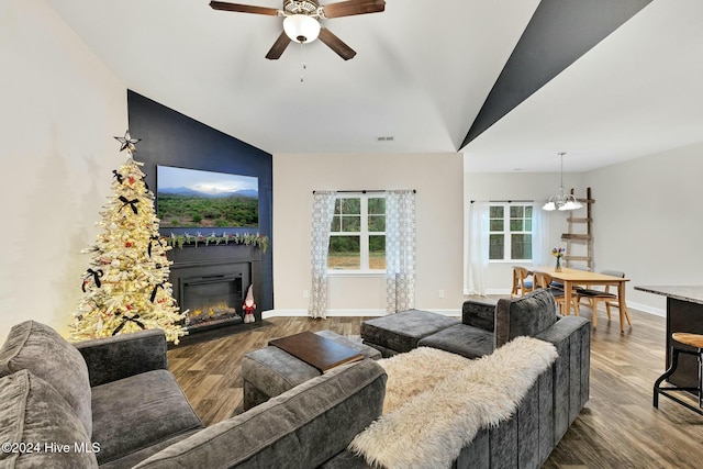 living room featuring ceiling fan with notable chandelier, lofted ceiling, and hardwood / wood-style flooring