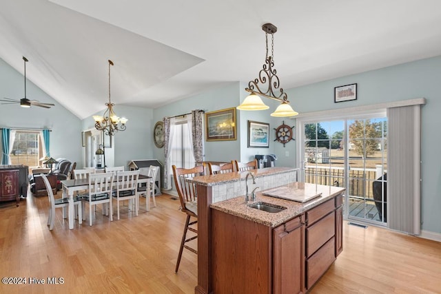 kitchen with a kitchen bar, a center island with sink, light hardwood / wood-style flooring, and sink