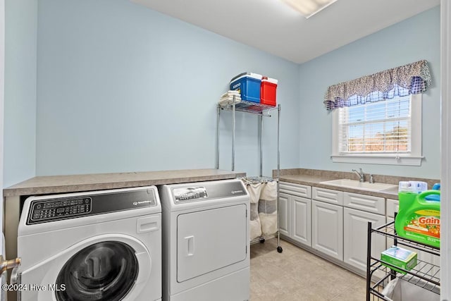 clothes washing area with cabinets, light tile patterned floors, washer and clothes dryer, and sink